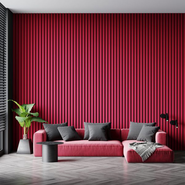 Contemporary living room with a magenta slatted accent wall, pink sofa, black pillows, plant, and side table.