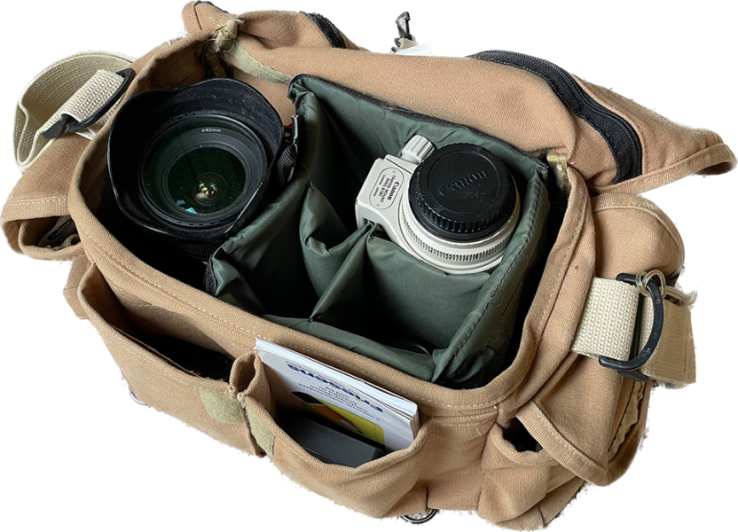 Open camera bag showing lenses and accessories neatly stored in padded compartments.
