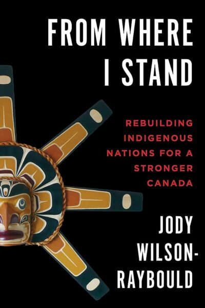 Cover of “From Where I Stand” by Jody Wilson‑Raybould, featuring a carved sun mask on a black background.