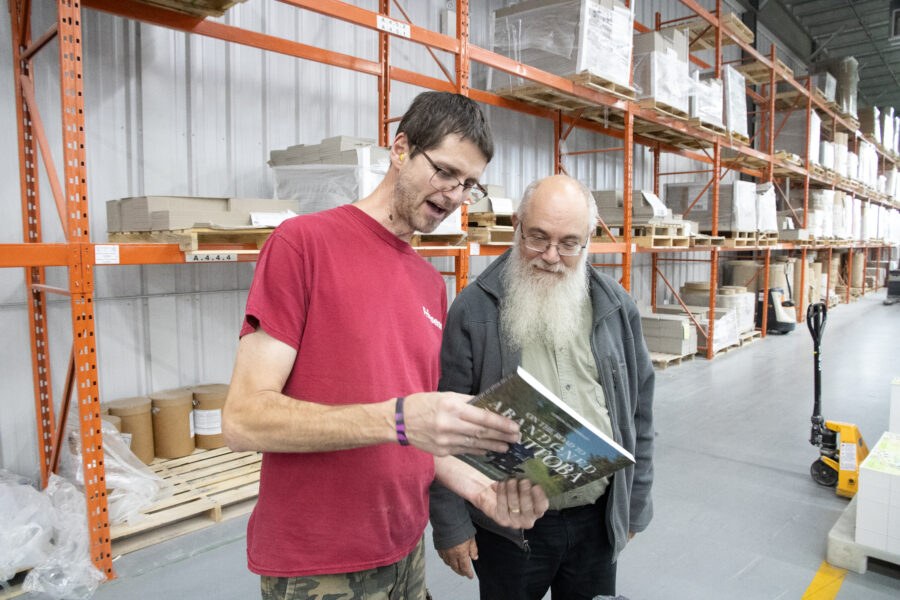 Two men looking at the back of a book