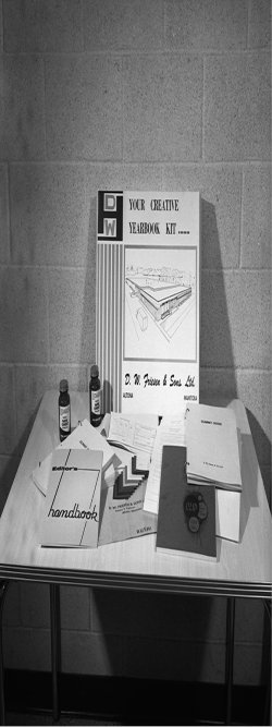 Table showcasing a Friesens creative yearbook kit with handbooks, sample pages, and layout materials.
