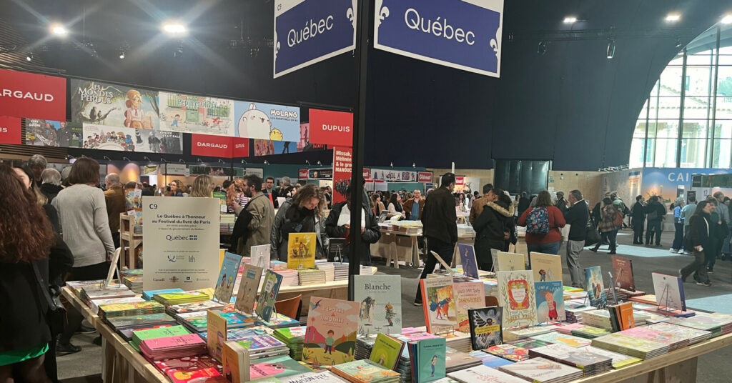 Book displays and visitors browsing the Québec section at the Festival du Livre.
