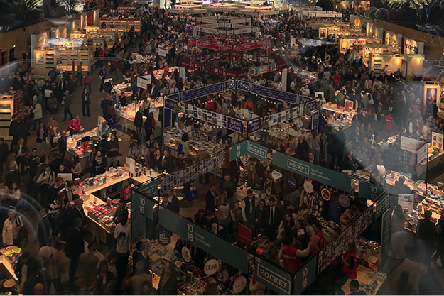 Large crowd exploring publisher booths and book displays at the Festival du Livre Paris event.