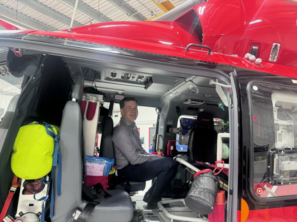 Person seated inside a STARS medical helicopter surrounded by emergency equipment and supplies.