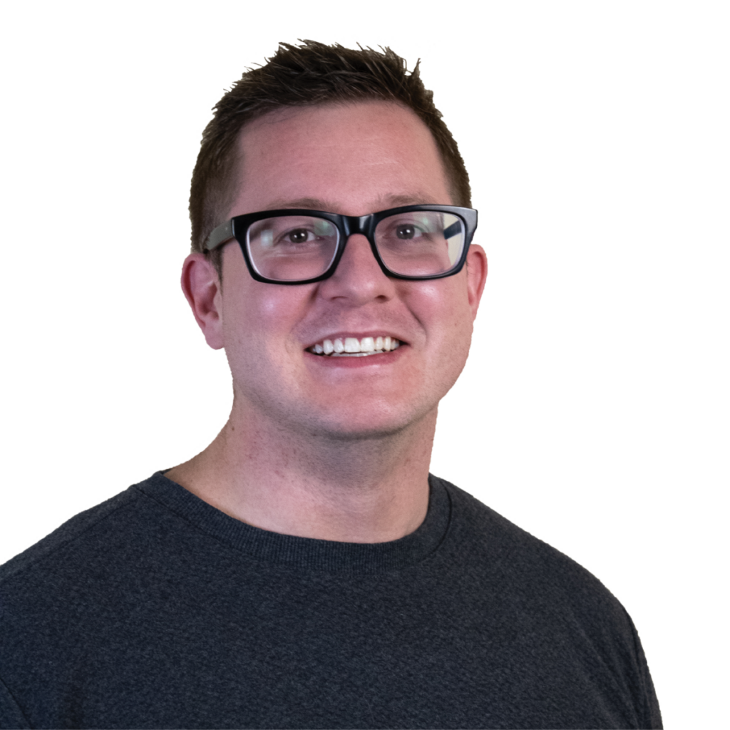 Person wearing a dark shirt standing against a plain white background.