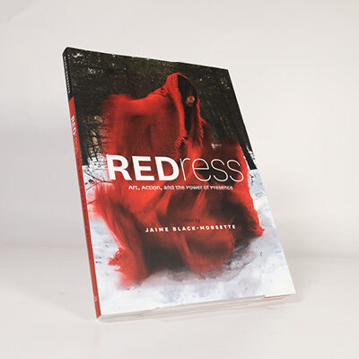 Book cover of REDress featuring a flowing red dress in a snowy forest background
