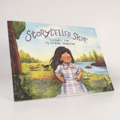 Illustrated book cover of Storyteller Skye showing a child standing by a river with trees and animals nearby