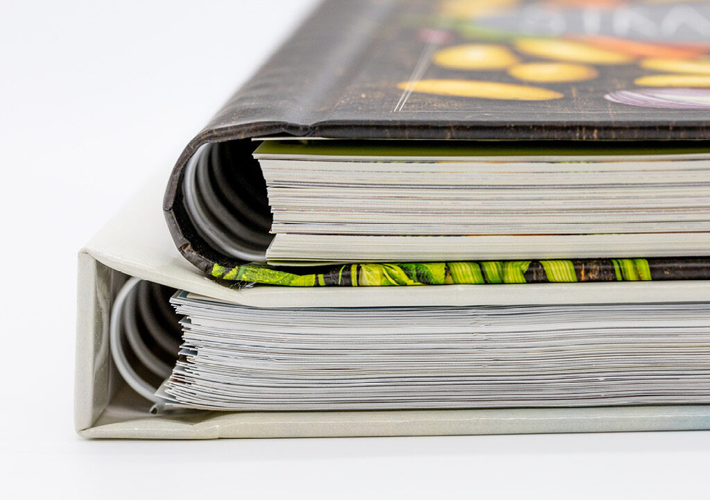 Close-up of two books showing concealed wire-o binding with coils hidden inside the hardcover spine