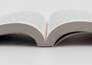 Open perfect bound book lying flat, showing curved pages and spine area.