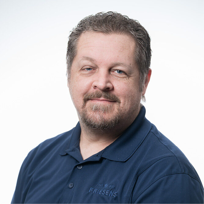 Person wearing a navy Friesens shirt in a studio-style portrait.