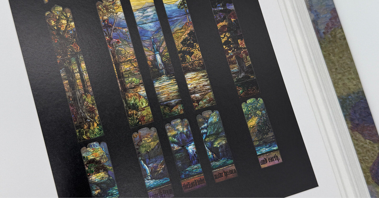 A printed page showing a set of tall, narrow stained‑glass window designs with colorful landscapes and nature scenes on a black background.