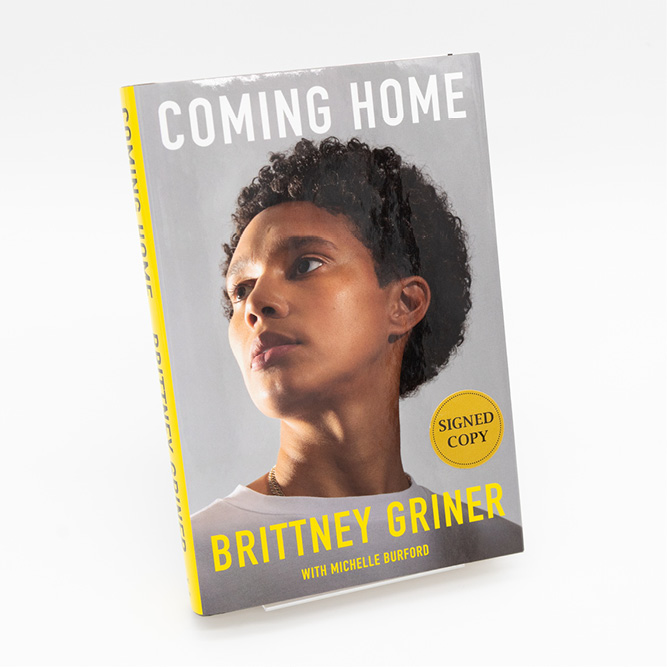 Cover of the book Coming Home by Brittney Griner, featuring a portrait of the author against a gray background with bold white and yellow text and a ‘Signed Copy’ sticker.