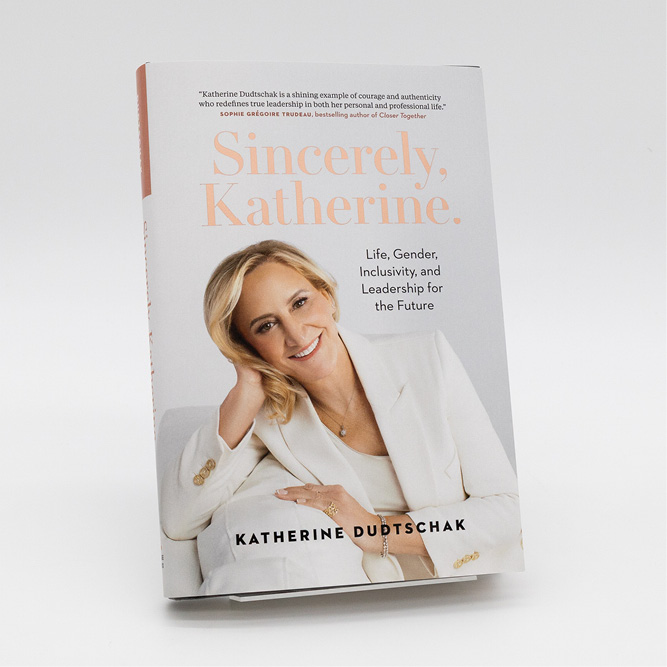 Cover of the book Sincerely, Katherine., featuring a woman in a white blazer seated at a table, with soft peach typography on a light background.