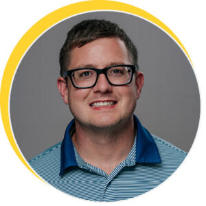 Person wearing a blue striped polo shirt with a grey background and a yellow circular border.