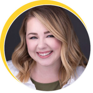 Person with shoulder-length wavy blonde hair wearing a white top over an olive shirt.