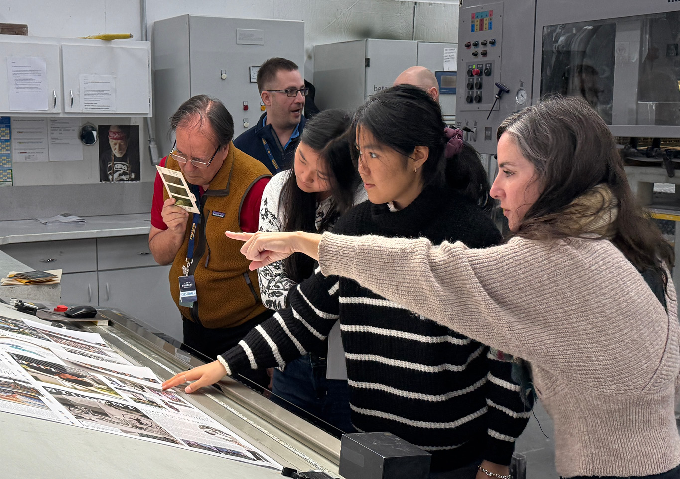 A group of people doing a press check in a book manufacturing facility