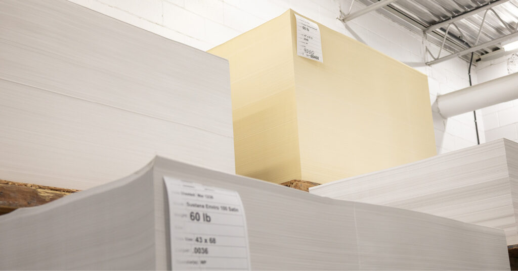 Stacks of paper showing a bright white sheet next to a warmer, yellow‑toned paper to demonstrate differences in paper shade.