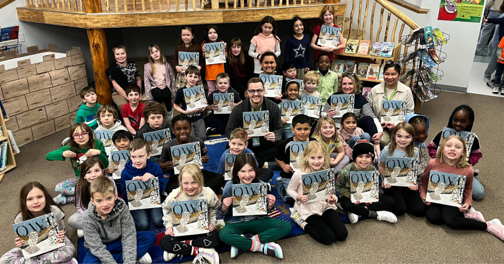 Group of Grade 2 students gathered in a school library, holding copies of Owl during an I Love to Read Month visit.