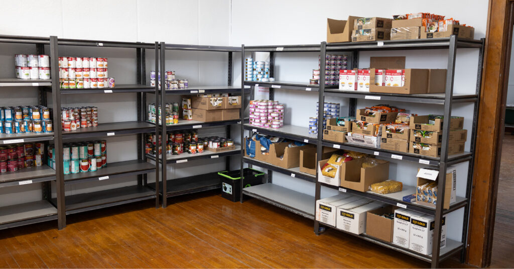 Shelves stocked with canned goods and food donations inside the Rhineland & Area Food Bank pantry.