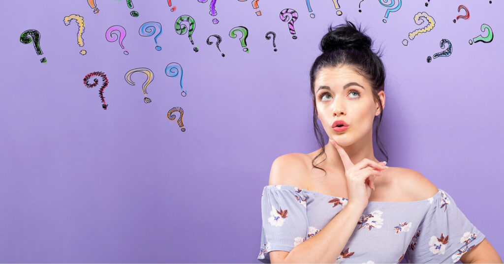 Person looking upward with hand on chin, surrounded by colourful question marks on purple background