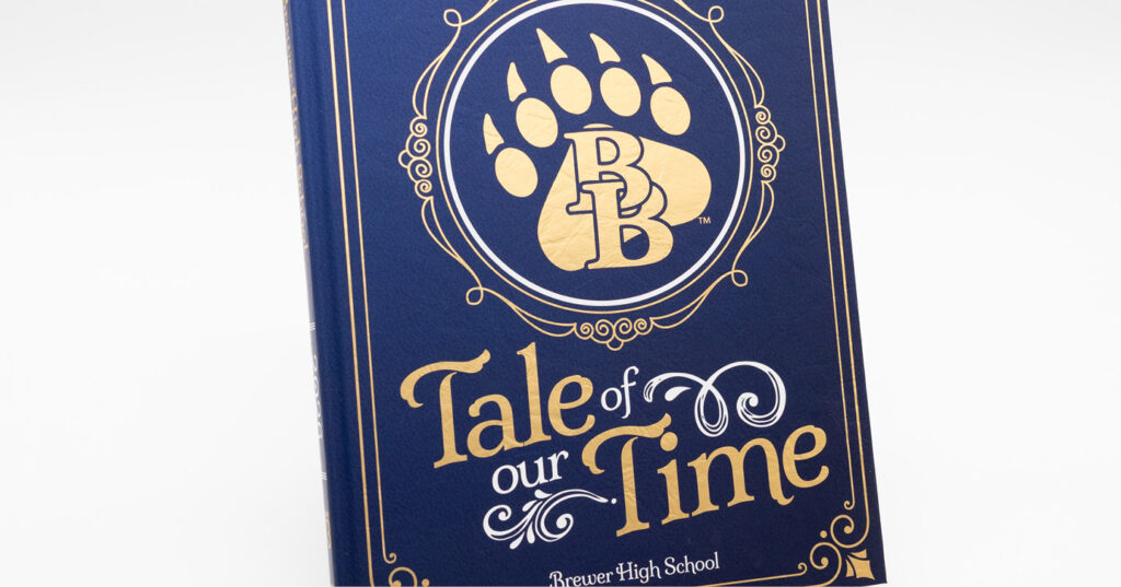 Blue yearbook cover with gold foil-stamped title, paw print logo, and decorative border details.